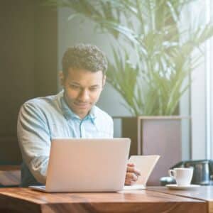 Handsome Arabian guy is making notes from computer