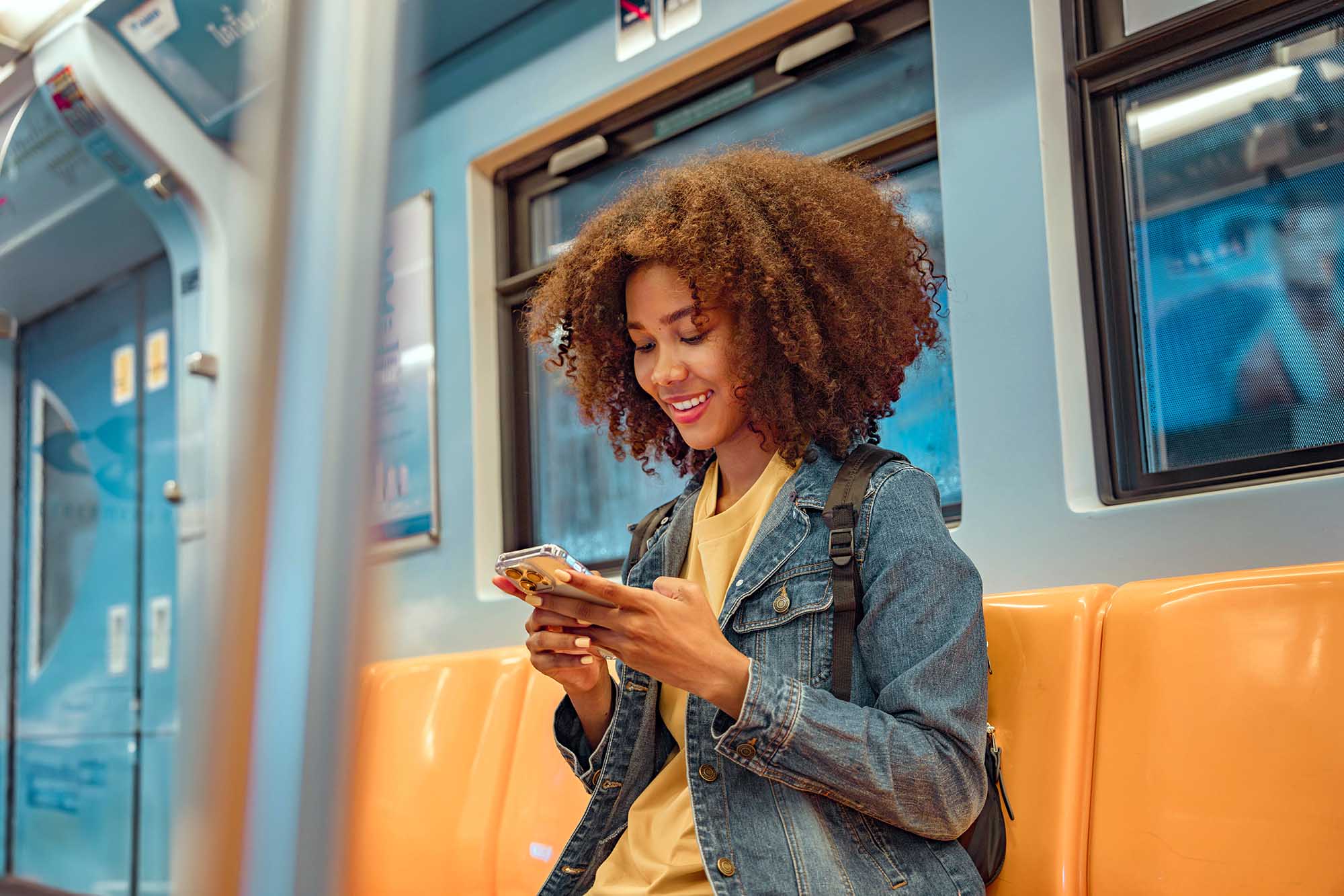 Happy young African American woman passenger smile and using sma
